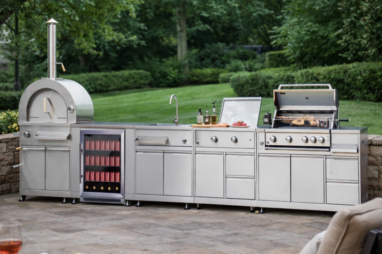 Modular outdoor kitchen with pizza oven and BBQ grill for garden entertaining